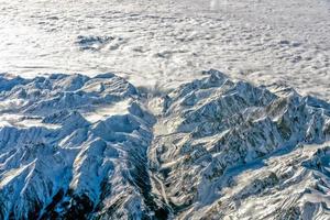 Alps mountains aerial view from airplane snow and avalanches photo