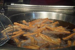 fried churros churro typical mexican sweet while frying photo