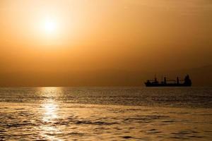 cargo ship silhouette at sunset photo