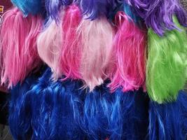 Colorful wig accessories. Sales at the market. Different wigs for women. photo