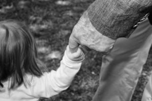 old retired man hands holding newborn infant one photo