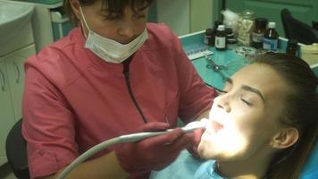charmantes junges Mädchen behandelt ihre Zähne von einem Zahnarzt video