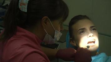 young charming girl at the dentist treats her teeth video