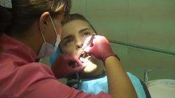 attractive young girl treats her teeth from a dentist video
