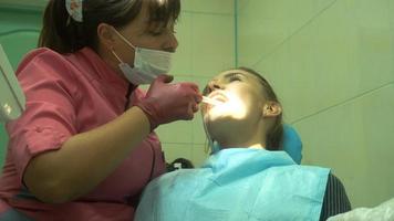 junges attraktives mädchen behandelt ihre zähne von einem zahnarzt