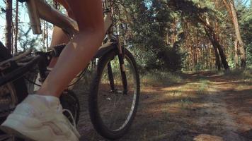 linda jovem dirigindo uma bicicleta na floresta em câmera lenta video