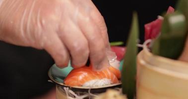 chef coloca cuidadosamente o caviar no prato de sushi gourmet - close-up shot video