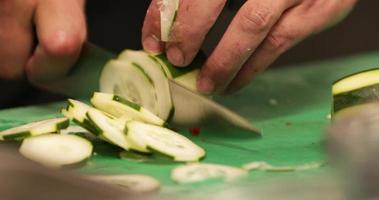 chef experto cortando pepino rápidamente con un cuchillo afilado en la cocina de un restaurante. - primer plano, tiro deslizante video