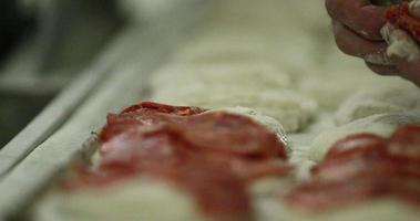 Baker Putting Pepperoni On Top Of Bread Before Cooking In The Oven. - close up shot video