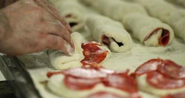 Peperonibrot - Bäcker, der mit Peperoni gefüllten Brotteig ausrollt. - Nahaufnahme video