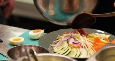 asiatisk sallad - kock sätta färsk skära tonfisk kött på de sida av vegetabiliska sallad. - stänga upp skott video