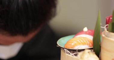 japanischer koch bei der arbeit, der ausgefallene sushi- und sashimi-platten herstellt - nahaufnahme video