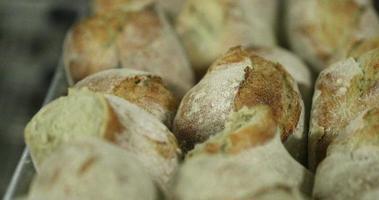 Frisch gebackenes Sauerteigbrot auf einem Tablett in der Bäckerei. -Nahaufnahme, gleitende Zeitlupenaufnahme video