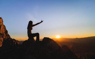 silueta de mujer cristiana rezando a mano, espiritualidad y religión, hombre rezando a dios. concepto de cristianismo. libertad y aventura de viaje. foto