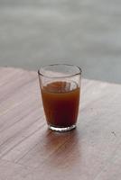 A glass of coffee on a wooden table photo