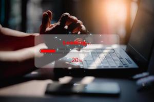 Man using laptop for download software and waiting to loading digital business data form website, concept of waiting for load of loading bar. photo