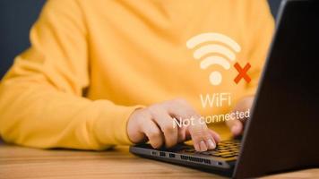 hombre usando una computadora portátil para conectarse a wifi pero wifi no conectado, y esperando para cargar el sitio web del formulario de datos comerciales digitales, tecnología conceptual de espera para conectarse a wifi. foto