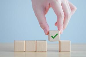 Elections and Voting, Vote, to do list, checklist, Task list, Survey and assessment concept. Hand pick green check mark on wooden block. photo