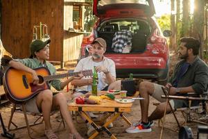 Group tourists drinking beer-alcohol and play guitar together with enjoy and happiness in Summer while camping photo