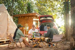 grupo de turistas amigos acampando y haciendo una barbacoa y bebiendo cerveza-alcohol con fiesta junto con disfrute y felicidad en verano foto