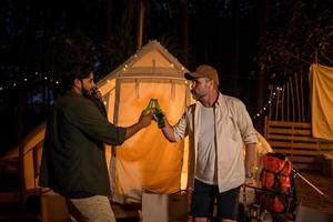 Group tourists Friends camping and having a barbecue and drinking beer-alcohol  and Crash a beer bottle with the party together with enjoyment and happiness in Summer photo