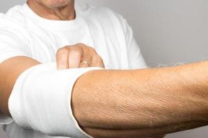 Man wearing an elastic type ace bandage on his elbow photo