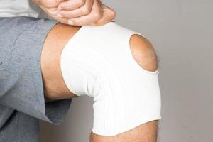 Man wearing an elastic type ace bandage on his knee photo