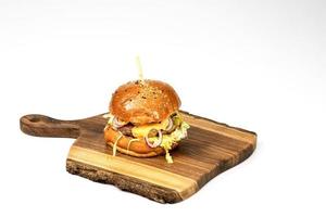 Fresh homemade hamburger on wooden serving board . White background with copy space photo
