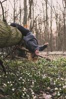 Laughing woman hanging on fallen tree scenic photography photo