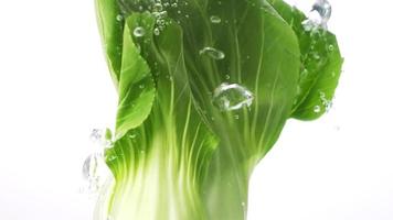 Fresh green vegetables dropping into the water, Concept organic food.