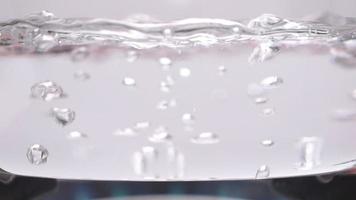 Vorderansicht des klaren Glastopfes mit kochendem Wasser auf dem Gasherd. video