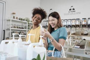 Two female customers are happy and enjoy shopping with natural organic products with recycled bottles at zero-waste and refill store, environment-friendly groceries, and sustainable lifestyles retail. photo