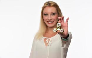 Girl to play with Fidget Spinner in his hands, the concept of relieving stress, develop a small hand mathematics. photo