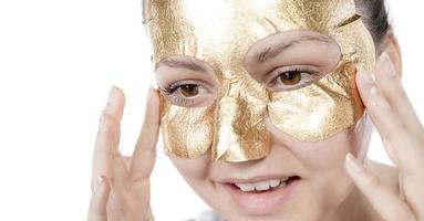 máscara de oro de mujer, hermosa modelo con cosmética de piel dorada, cuidado y tratamiento de la piel de belleza
