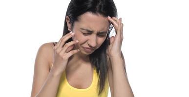 Young beautiful woman has headache, isolated on gray background. Exhausted girl portrait photo