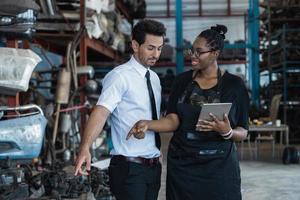 Sales service staff woman recommends old auto parts  with happy and service mind in warehouse photo