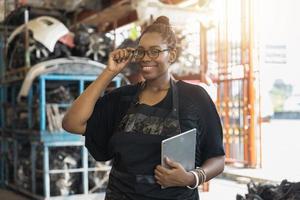Portrait of confident African woman in old parts of car factory photo