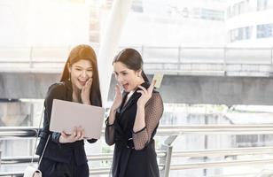 shopping online and lifestyle concept, two women looking on laptop and holding credit card for buying by searching internet photo