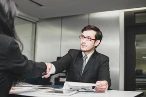 el hombre de negocios le da la mano al candidato después de terminar la entrevista para un trabajo foto