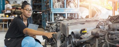 Portrait of confident African woman check and working in old parts of car factory