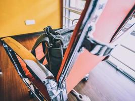 A canvas bag resting on an orange chair in an office photo