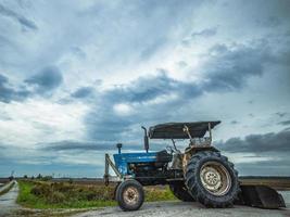 A blue tractor at the rice field photo