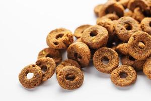 Granules of dry fodder in the shape of a rings for dogs on a white background photo