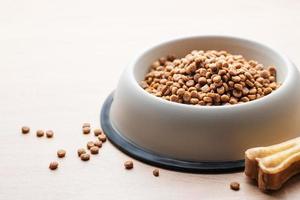 A bowl of dog food on a wooden floor. photo