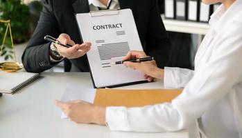 empresarios y abogados discutiendo documentos contractuales sentados a la mesa. conceptos de derecho, asesoría, servicios legales. a la luz de la mañana foto