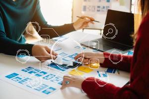 UX developer and ui designer brainstorming about mobile app interface wireframe design with customer breif and color code at modern office. photo