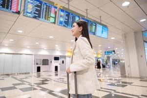 A young beautiful woman walking with suitcase , check in at International airport , vacation travel and transportation concept photo