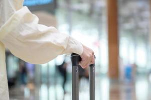 Close-up woman hand walking with suitcase , check in at International airport , vacation travel and transportation concept photo