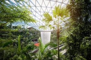 Changi, Singapore - 26.12.2022  Jewel Changi Airport , artificial waterfall dome with plants where is most famous eco landmark combined with shopping mall in Changi Airport . photo