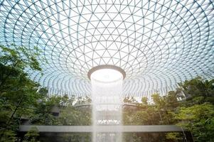 Changi, Singapore - 26.12.2022  Jewel Changi Airport , artificial waterfall dome with plants where is most famous eco landmark combined with shopping mall in Changi Airport . photo